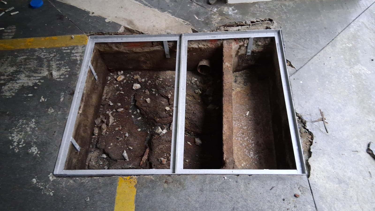 Antes: aberturas no piso de concreto com moldura metálica recém-instalada